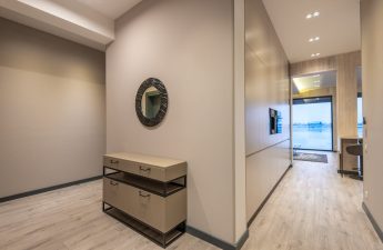 przedpokój z okrągłym lustrem na ścianie nad komodą